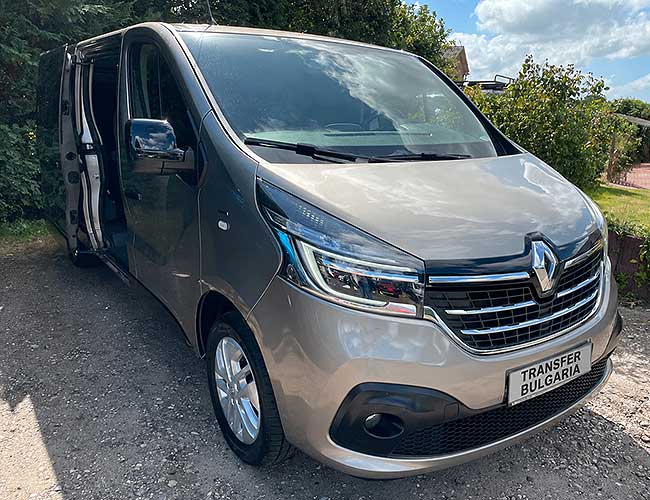 Grey Renault Trafic minibus, front three-quarter view, side sliding door open